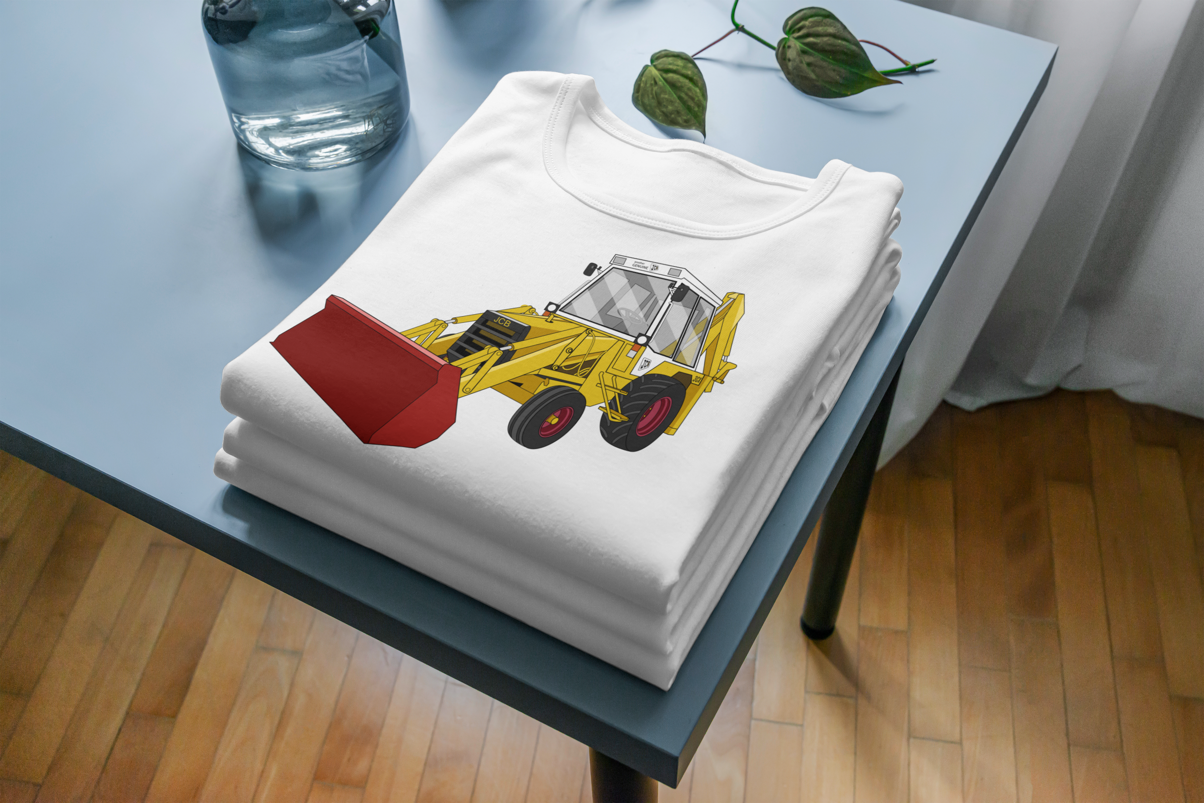 Stack of folded white t-shirts with a yellow bulldozer design on a light blue table.